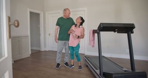 Elderly couple enjoying relaxed exercise at home