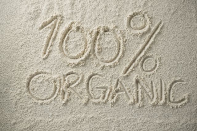 Text '100% Organic' written in flour, emphasizing natural and healthy food ingredients. Ideal for use in marketing materials for organic food products, eco-friendly campaigns, and healthy eating promotions.