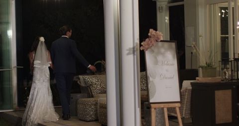 Newlyweds Walking Inside Elegant Wedding Venue at Night