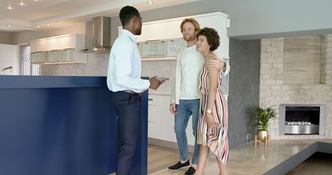 Estate Agent Showing Modern Home to Happy Couple