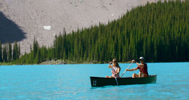 Couple Kayaking on Turquoise Lake with Scenic Forest and Mountains - Download Free Stock Photos Pikwizard.com