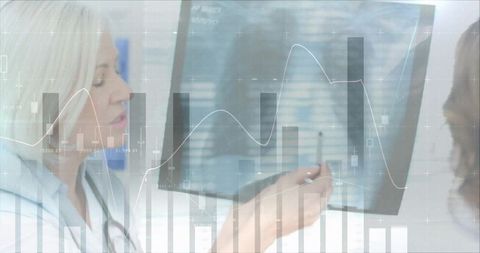 Female doctor pointing at digital medical charts on monitor with analytics and graphs