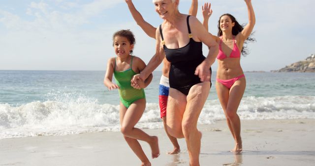 Family members of different generations are running together on a sandy beach, having fun near the ocean waves. This can be used to depict family bonding, outdoor activities, summer vacations, and healthy, active lifestyles. Ideal for advertisements, family events, vacation promotions, and health articles.