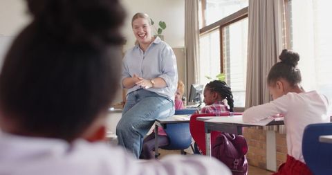 Engaging teacher interacting with elementary students in classroom