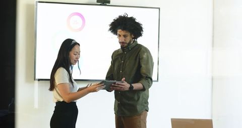 Professional Colleagues Collaborating with Technology in Office