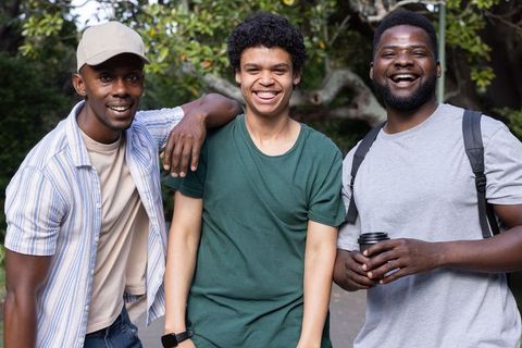 African american friends laughing and smiling in park, casual urban lifestyle