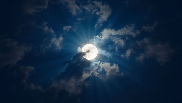 Full Moon Illuminating Clouds in Serene Night Sky
