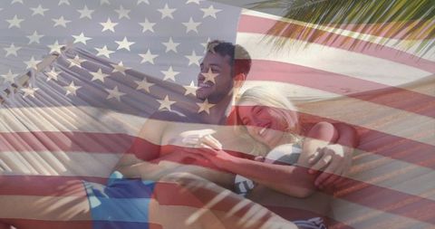 Couple relaxing on striped hammock beneath palm fronds with american flag overlay, tropical beach