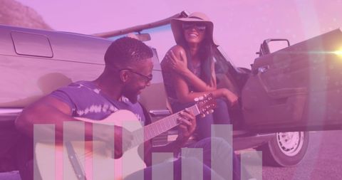 Joyful couple enjoying music by roadside classic car