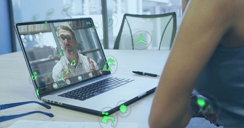 Consultant presenting green energy icons during virtual video conference on laptop screen