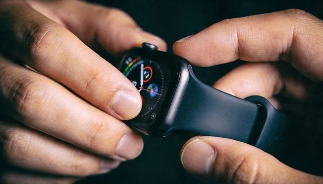 Hands adjusting smartwatch digital crown tapping silicone strap closeup