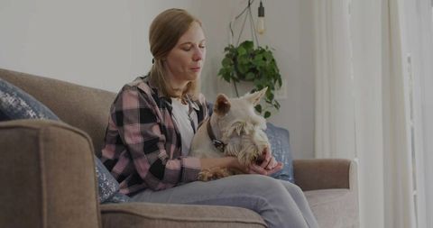 Woman Relaxing at Home with Terrier Dog on Sofa