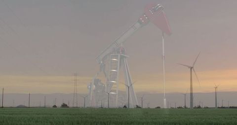 Contrast of Energy Generation: Oil Pump Jack and Wind Turbines in Meadow