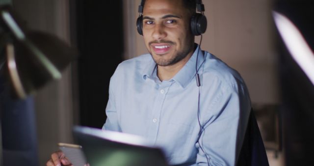 Confident Man Working Late with Headphones Listening to Music - Download Free Stock Images Pikwizard.com