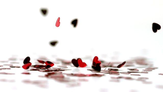 Red heart confetti falling in slow motion on a white background. Ideal for use in celebrating romantic events, such as Valentine's Day, anniversaries, weddings, or lovethemed parties. These elements can enhance invitations, social media posts, promotional materials, and website banners that revolve around love and romance.