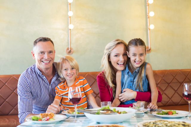 Family enjoying meal at restaurant, perfect for advertisements about family-friendly dining, lifestyle blogs, or promotional materials for restaurants. Highlights joy and togetherness, suitable for use in family-oriented marketing campaigns.
