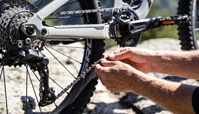 Repairing mountain bike chain quick link on rocky trail closeup drivetrain maintenance