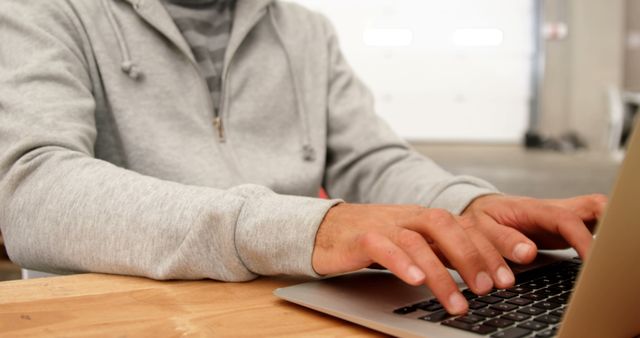 Person Typing on Laptop in Casual Grey Hoodie Indoors - Download Free Stock Images Pikwizard.com