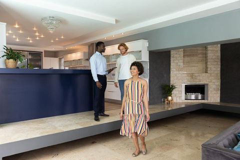 Real Estate Agent Showcasing Modern Open-Plan Home to Clients