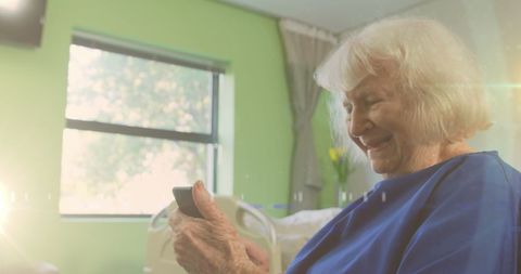 Senior Woman Engaging with Smartphone in Sunlit Room