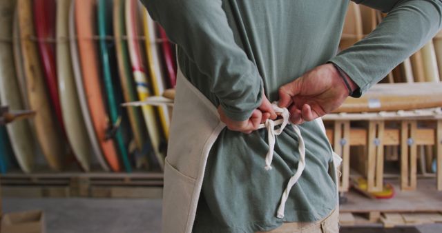 Person Tying Apron in Surfboard Workshop - Download Free Stock Images Pikwizard.com