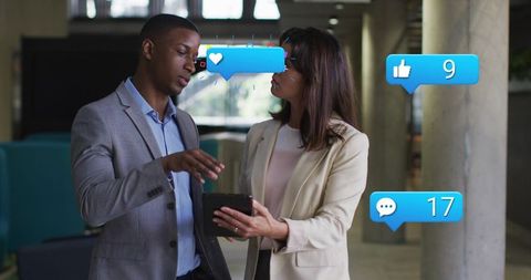 Business professionals discussing social media engagement via tablet in office lobby