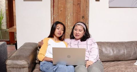 Mother and Daughter Bonding at Home with Laptop Lounge