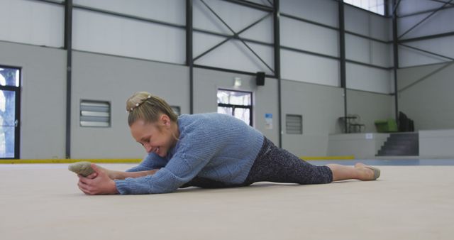 Young Woman Stretching on Floor in Gymnasium for Warm-Up - Download Free Stock Images Pikwizard.com