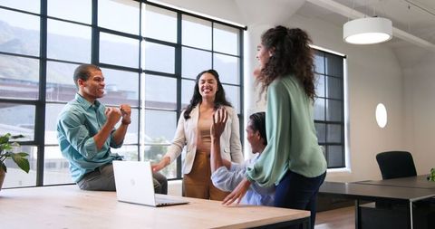 Diverse Coworkers Celebrating Success in Modern Office