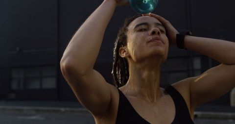 Exhausted Woman Cooling Down with Water After Intense Workout