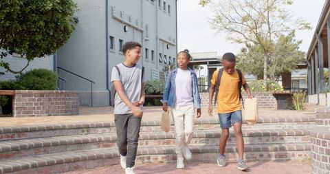 Diverse Children with Lunch Bags and Backpacks in School Courtyard