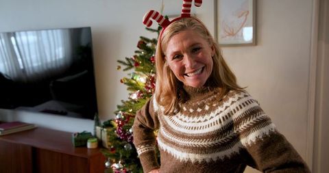 Cheerful Woman in Reindeer Antlers Celebrating Christmas