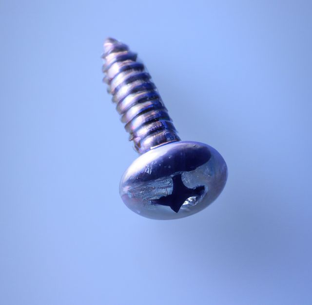 Image of close up of metal screw with copy space on blue background. Screw and fixing diy items concept.