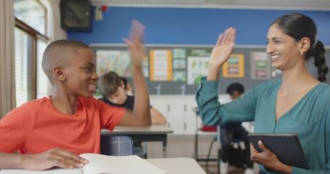 Teacher and student sharing high five in classroom setting