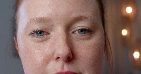 Close up portrait of woman with freckles looking at camera