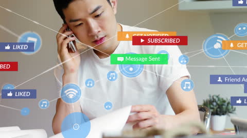 Asian Man Engaged with Social Media Icons While Multitasking at Home