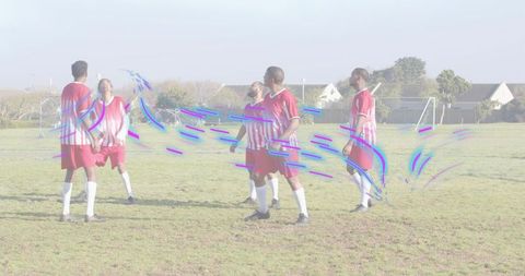 Men's soccer players practicing aerial ball control and tracking on suburban grass field