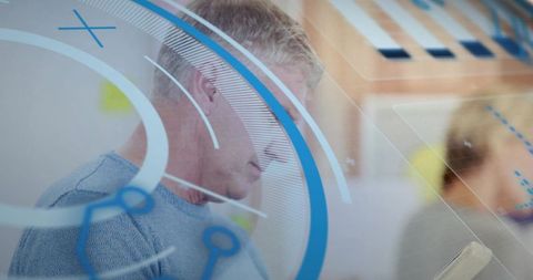 Senior professional studying tablet through AR interface with blue HUD overlay