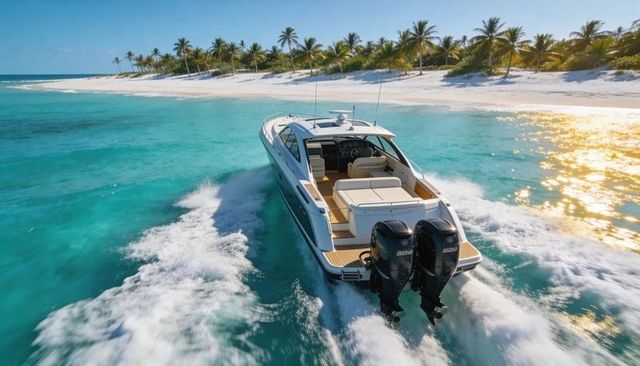 Cruising luxury yacht cutting turquoise lagoon by palm-fringed white beach at sunrise