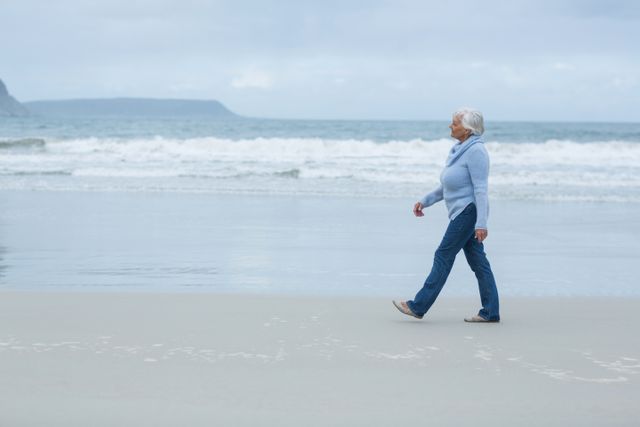 Smiling senior woman walking on the beach