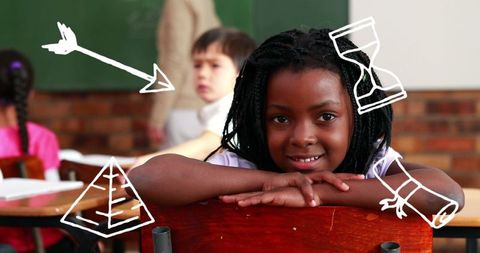 Joyful schoolchild in classroom with educational icons overlay