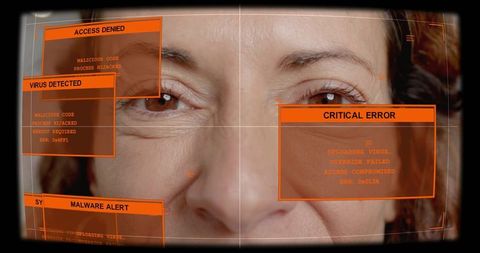 Senior woman staring through visor with orange hud alerts, crosshair and critical malware warnings