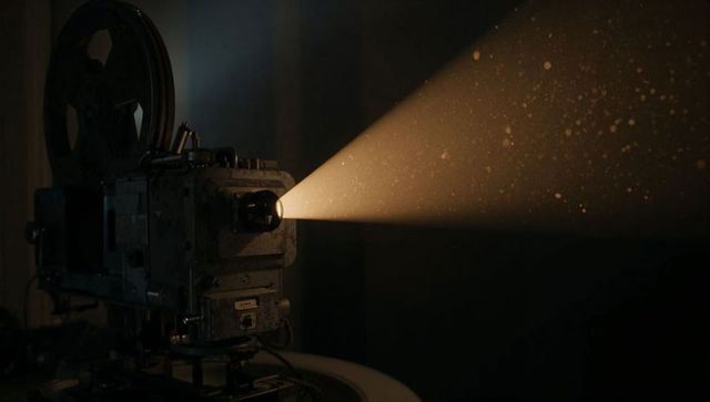 Antique Film Projector Casting Mystical Beam of Light Through Dust
