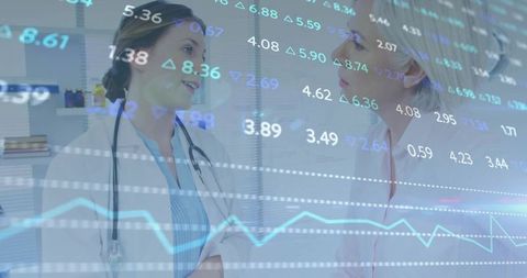 Female clinicians discussing healthcare analytics with digital charts overlay, cyan