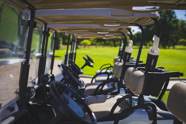 View of multiple golf carts parked at golf course on a bright sunny day. sports and active lifestyle concept.