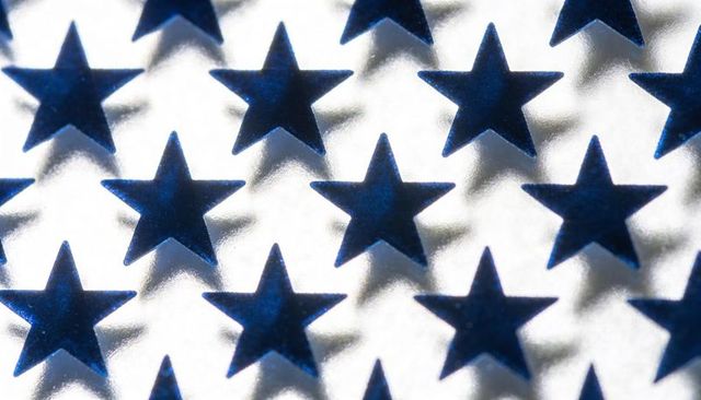 Blue Metallic Star Pattern on Silver Reflective Surface Featuring Embossed Stars