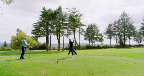 Senior Couple Golfing on Lush Course Amid Beautiful Nature