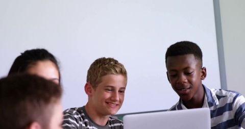 Teen Students Collaborating at Laptop in Classroom Smiling and Learning Together