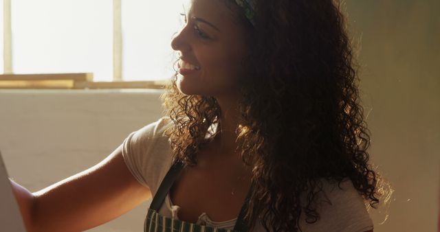 Smiling Woman with Curly Hair Painting Indoors in Natural Light - Download Free Stock Images Pikwizard.com