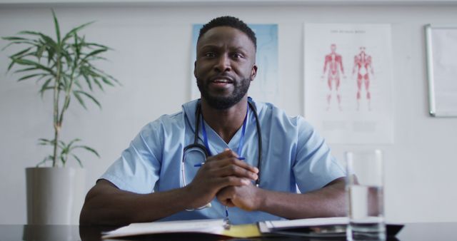 This is a perfect representation for use in medical websites, healthcare blogs, and hospital brochures. The doctor appears professional and approachable, making the photo suitable for patient information leaflets, online medical consultations, or healthcare service promotions. The visible anatomical charts in the background enhance the medical and professional ambiance.